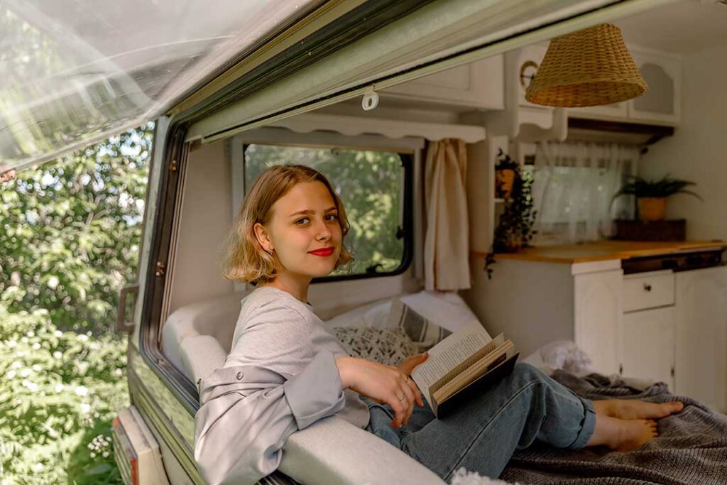 Young lady relaxing and reading in an RV